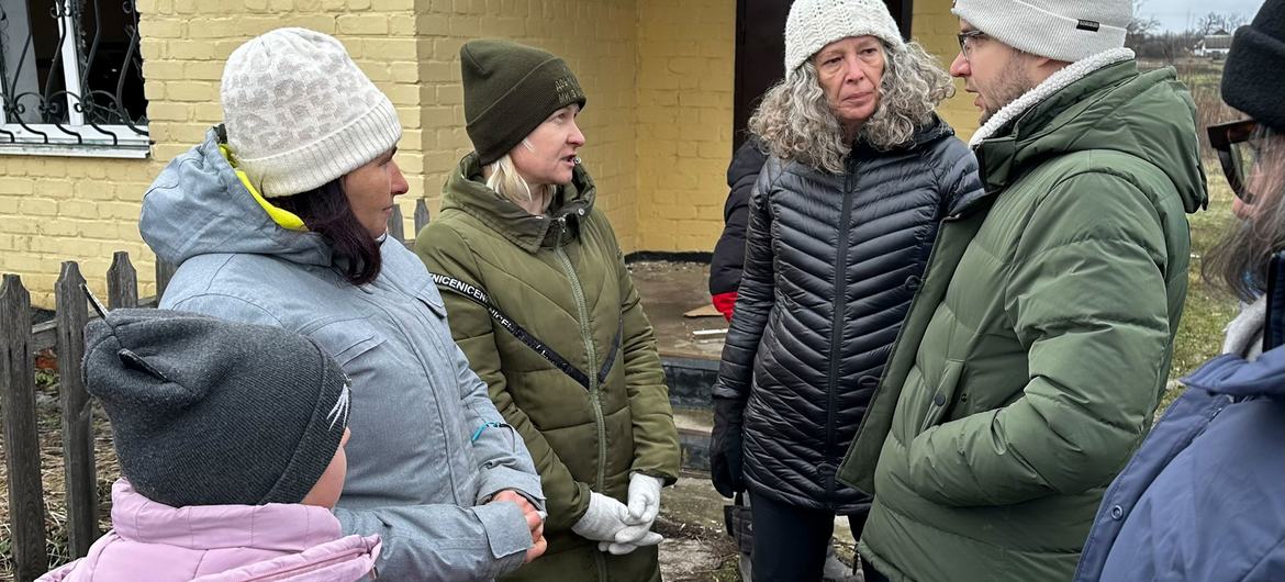 The Humanitarian Coordinator and Head of the United Nations in Ukraine, Denise Brown (centre right), talks to residents of Hroza on the frontline in Ukraine.