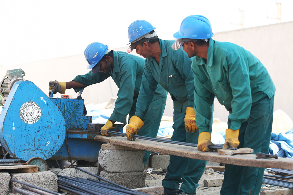 Foreign workers cut steel on a construction site in the United Arab Emirates.